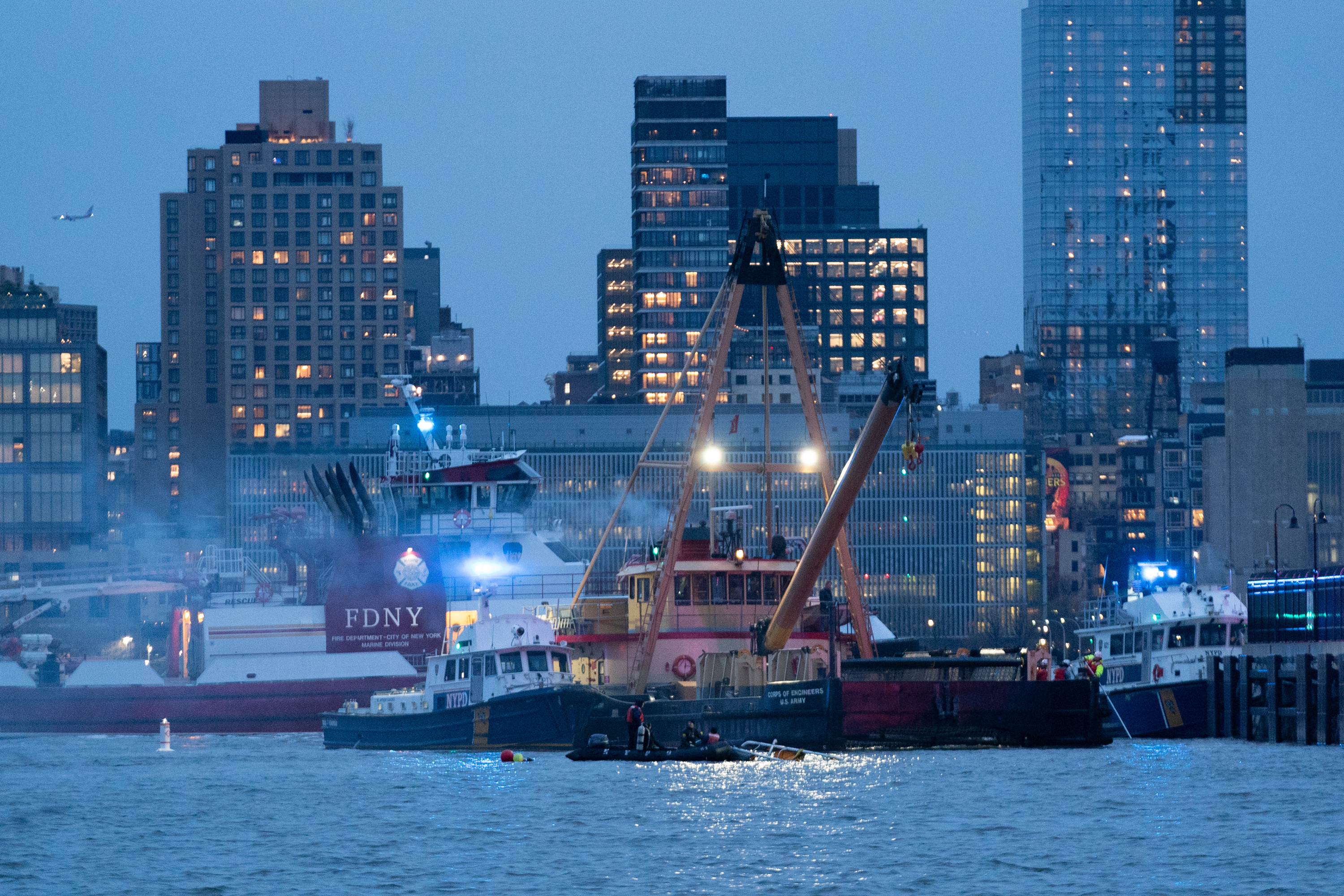 Emergency crew pulling helicopter parts out of the water. | Source: Getty Images