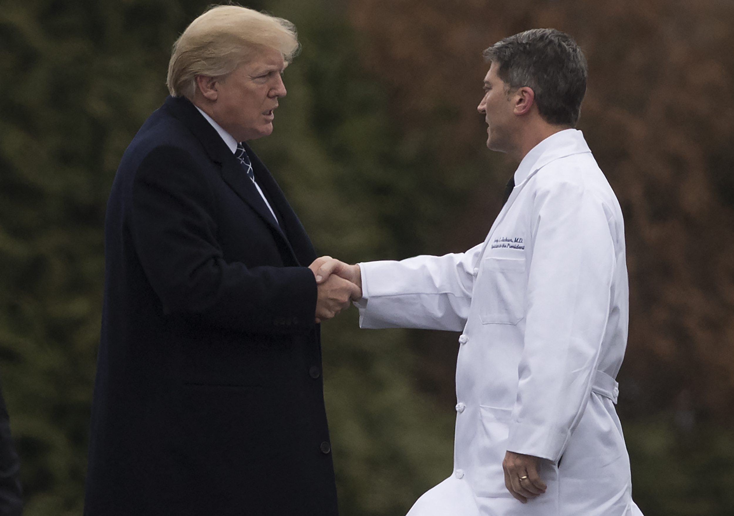 Donald Trump shakes hands with Dr. Ronny Jackson, following his annual physical at Walter Reed National Military Medical Center in Bethesda, Maryland, on January 12, 2018 | Source: Getty Images
