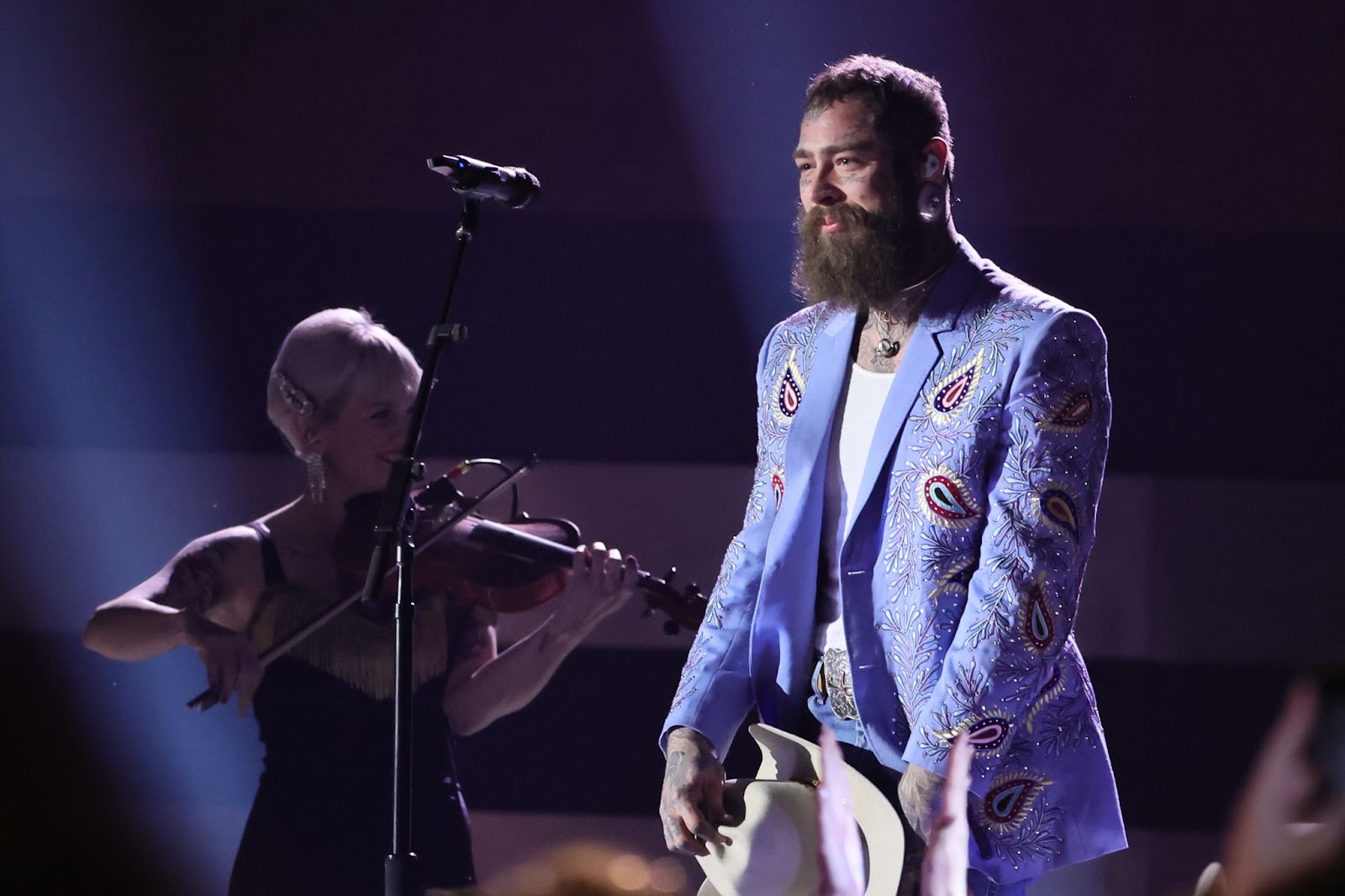 Post Malone holds his hat onstage at Bridgestone Arena | Source: Getty Images