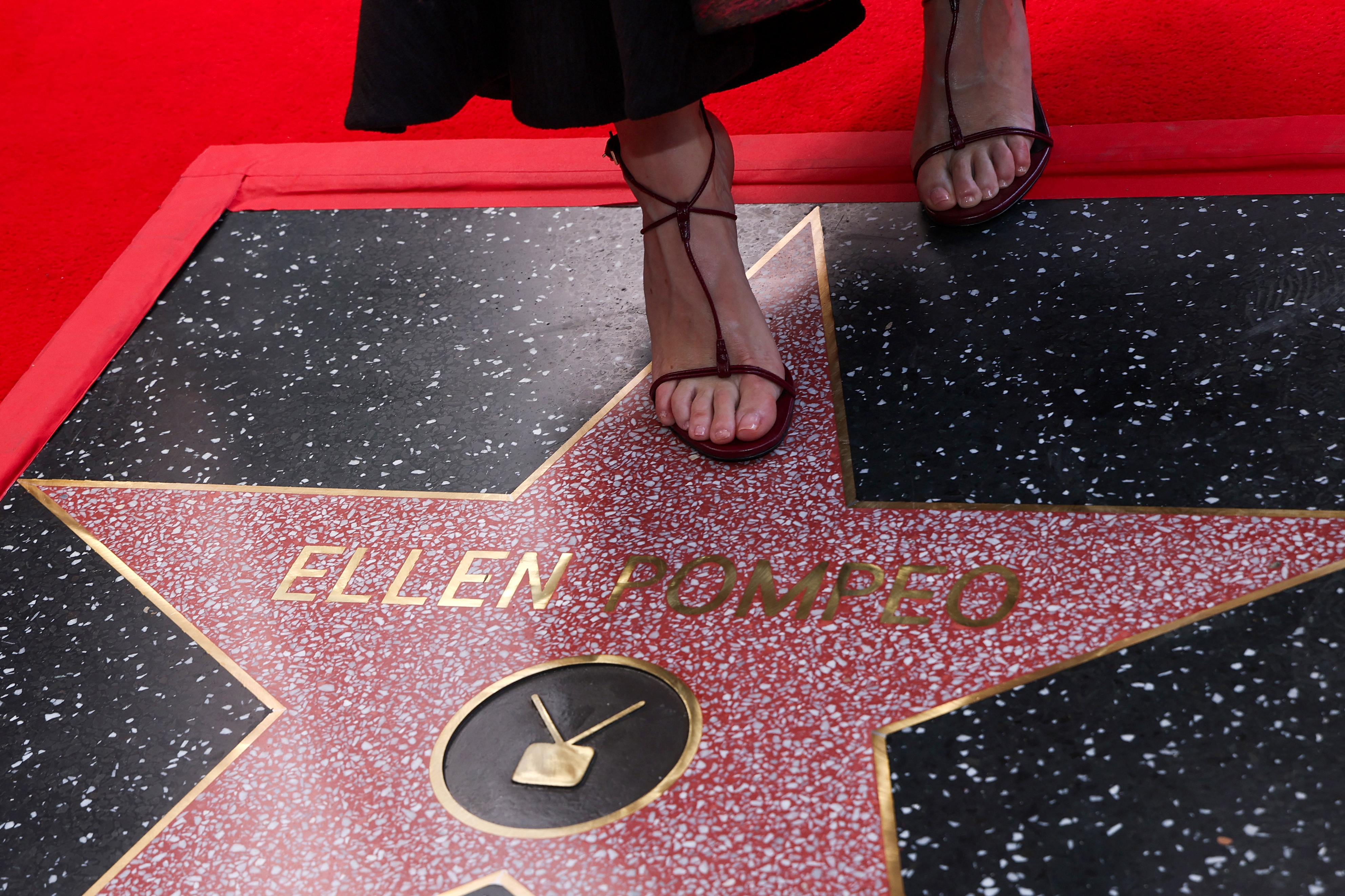 Ellen steps gracefully onto her newly unveiled Hollywood Walk of Fame star, her strappy heels resting right above the gold lettering of her name.