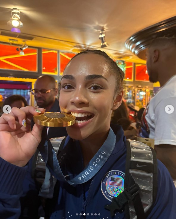 Hezly "Hez" Rivera biting on her Paris Olympics gold medal in a social media post uploaded on July 30, 2024 | Source: Instagram/hezrivera
