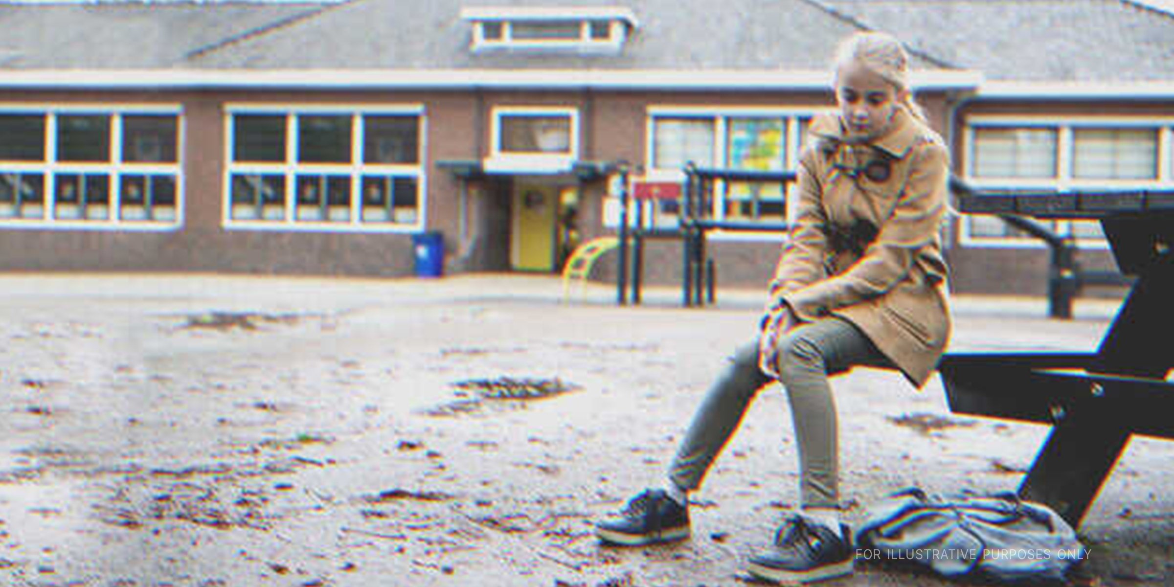 Girl sitting outside a school building. | Source: Getty Images