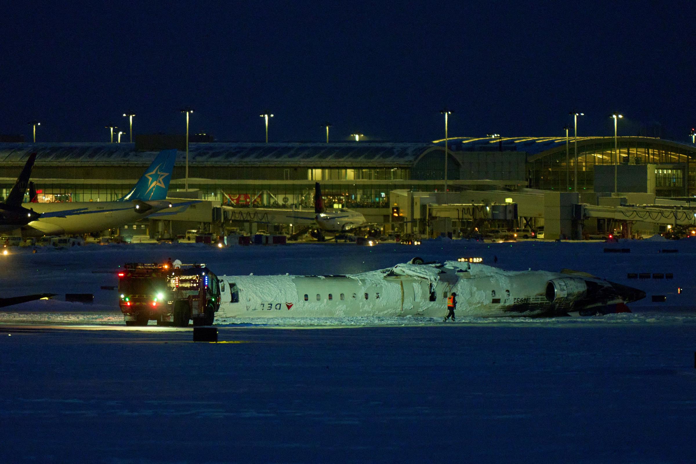 A Delta Airlines plane sits on its roof after crashing upon landing at Toronto Pearson Airport | Source: Getty Images