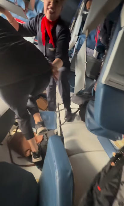Inside the plane, a flight attendant assists passengers as they navigate through overturned seats and scattered debris | Source: Instagram/eggxit