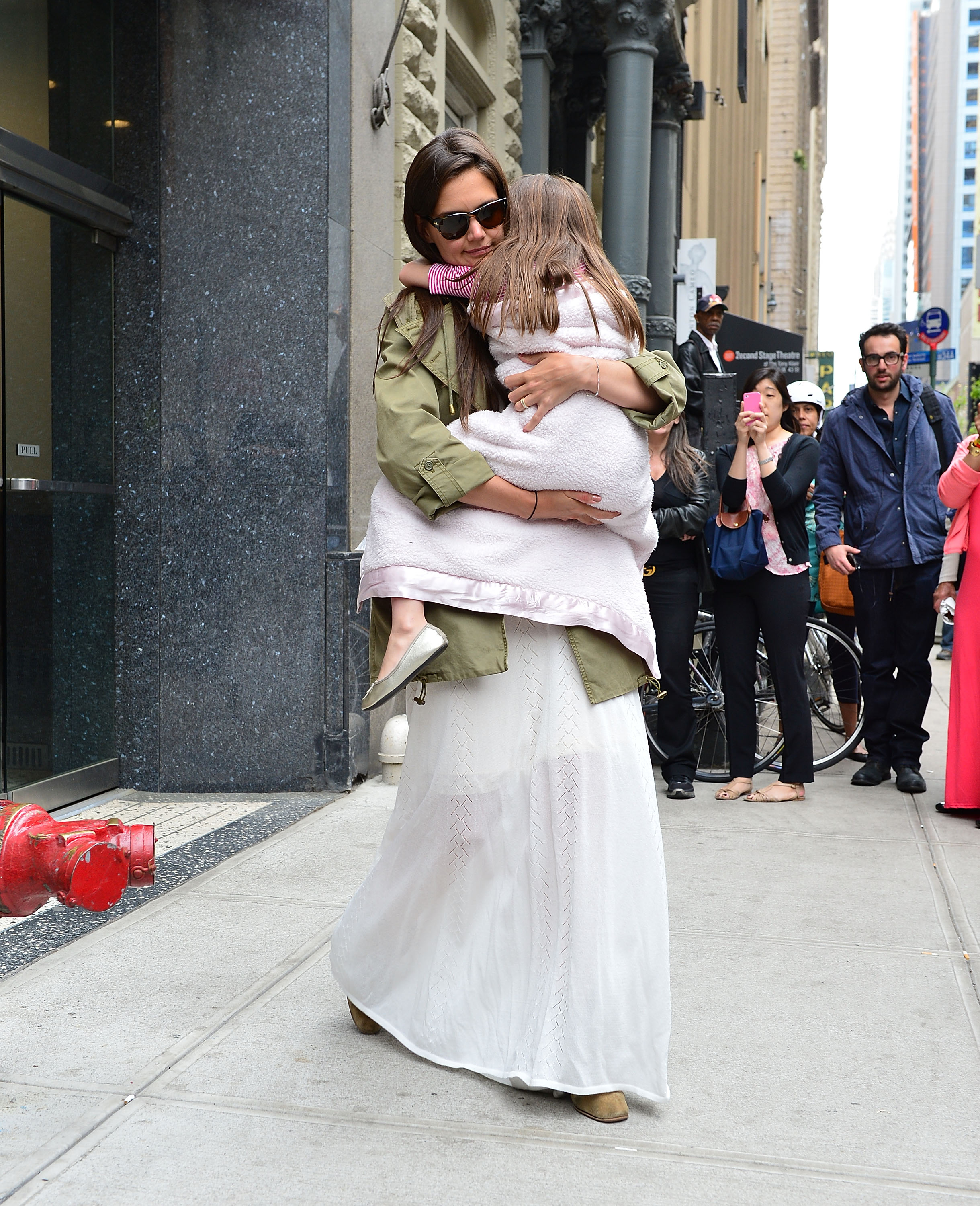 Katie Holmes hugs her daughter, Suri Cruise, as they walk through Manhattan, New York on April 18, 2012. | Source: Getty Images